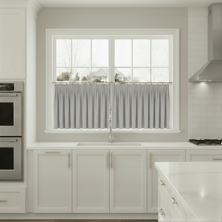 Modern kitchen with white cabinets, a window, and stainless steel appliances.