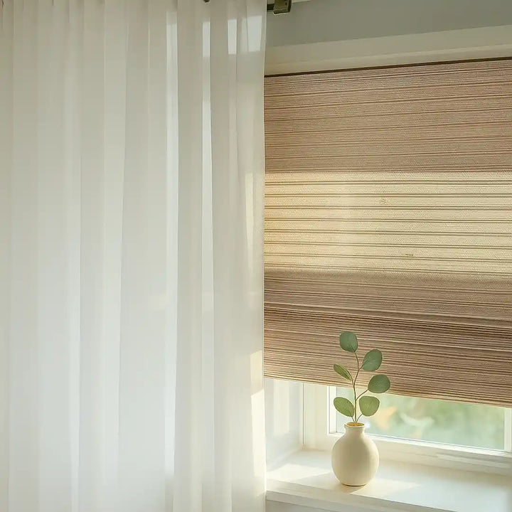 Woven bamboo Roman shade with soft sunlight and sheer white curtain.