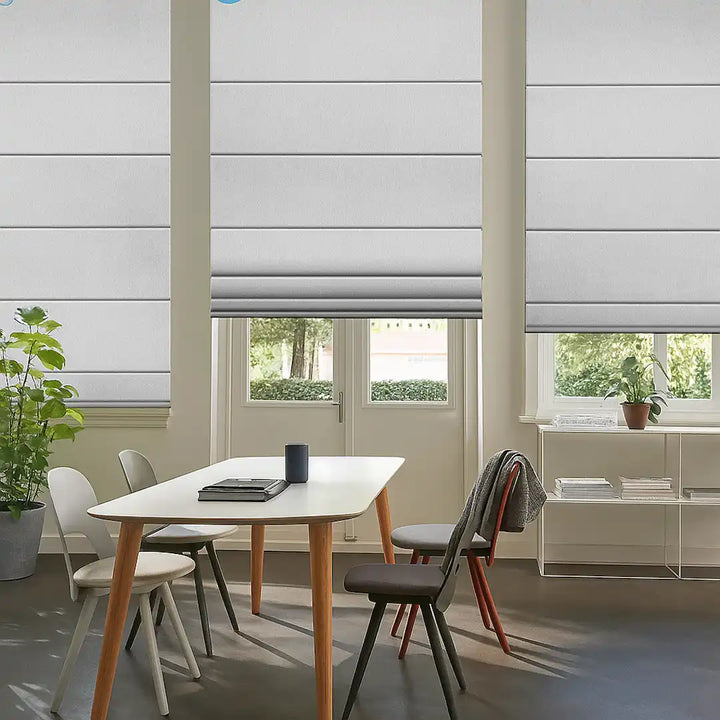 Dining area with white Roman shades over large windows and a modern table