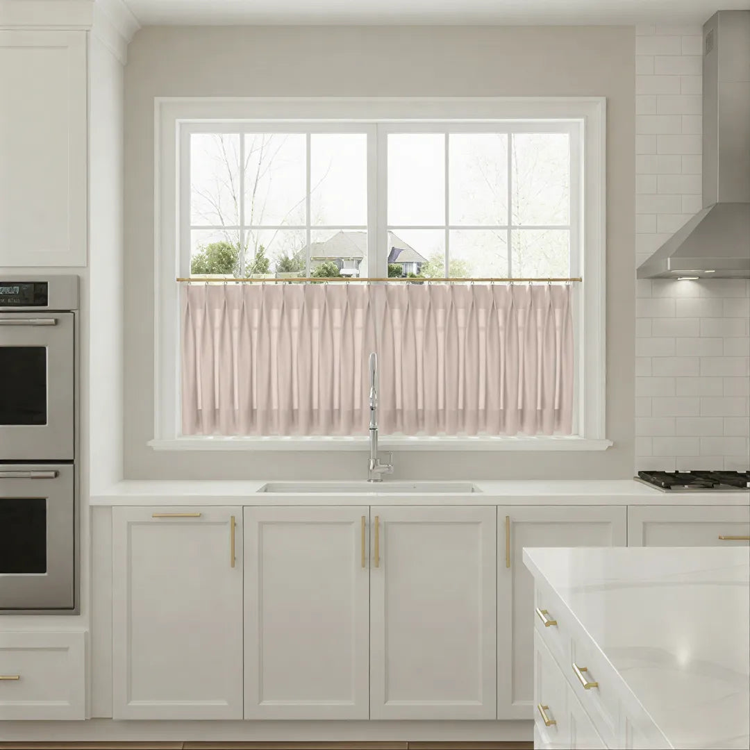 Modern kitchen with white cabinets, a window with pink curtains, and stainless steel appliances.
