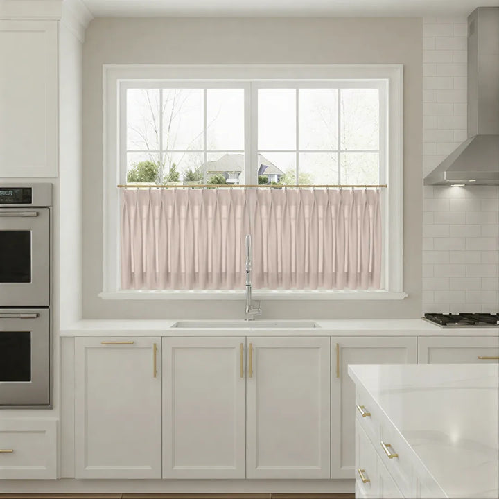 Modern kitchen with white cabinets, a window with pink curtains, and stainless steel appliances.