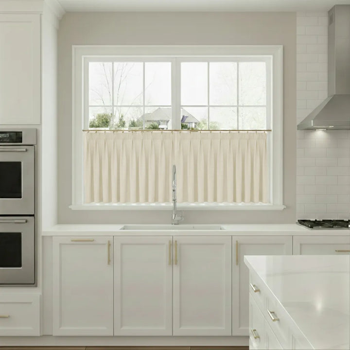 Modern kitchen with white cabinets, a window, and stainless steel appliances.